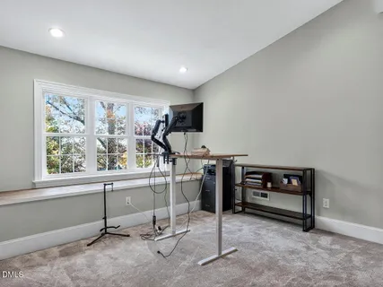 a view of a workspace with furniture and a window