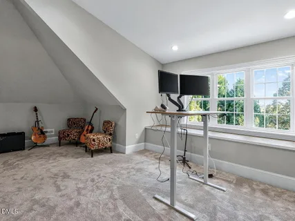 a living room with furniture a flat screen tv and floor to ceiling window