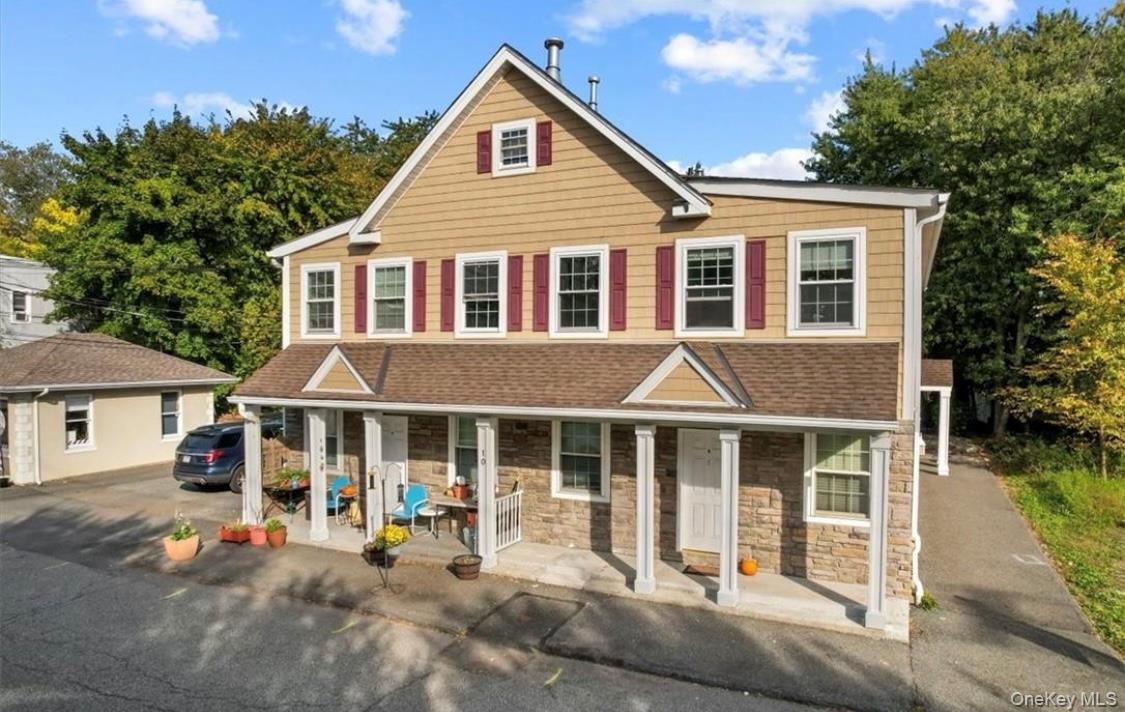 a front view of a house with a yard and seating space