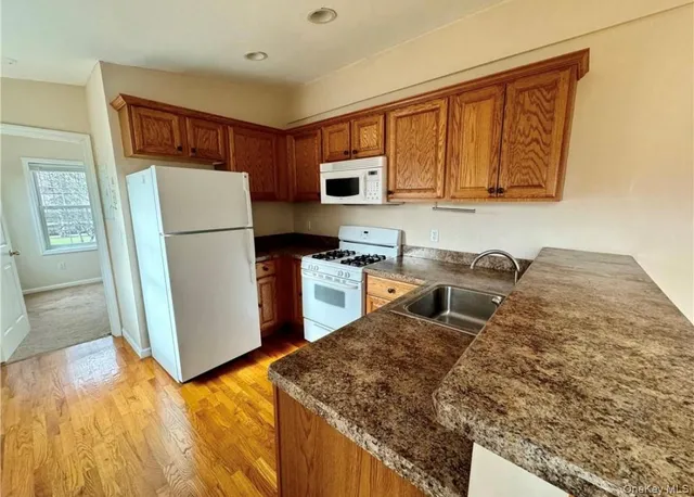 a kitchen with granite countertop a refrigerator and a stove top oven
