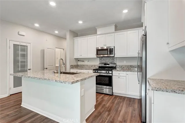 a kitchen with stainless steel appliances granite countertop a sink stove and refrigerator