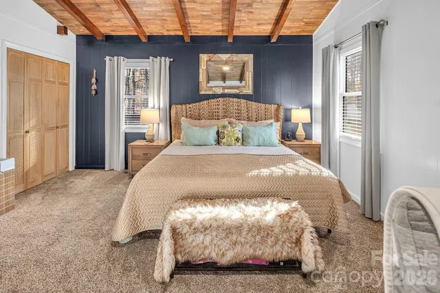 a bed sitting in a bedroom next to a window