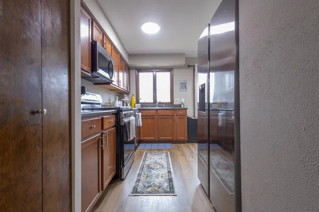 a kitchen with stainless steel appliances granite countertop a refrigerator and a sink