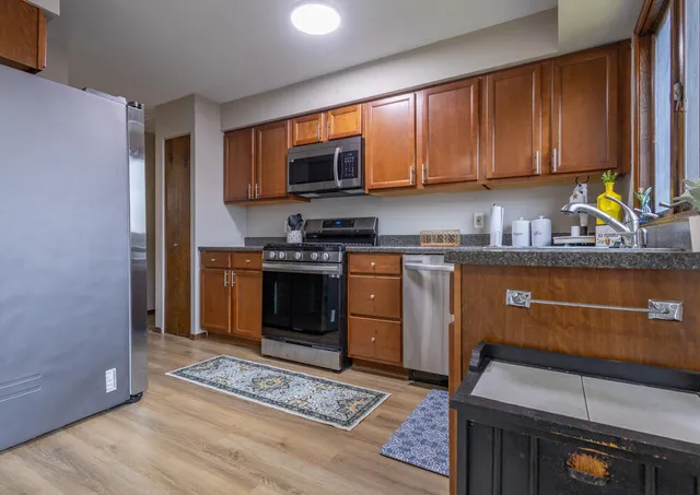 a kitchen with stainless steel appliances granite countertop a stove a sink and a microwave