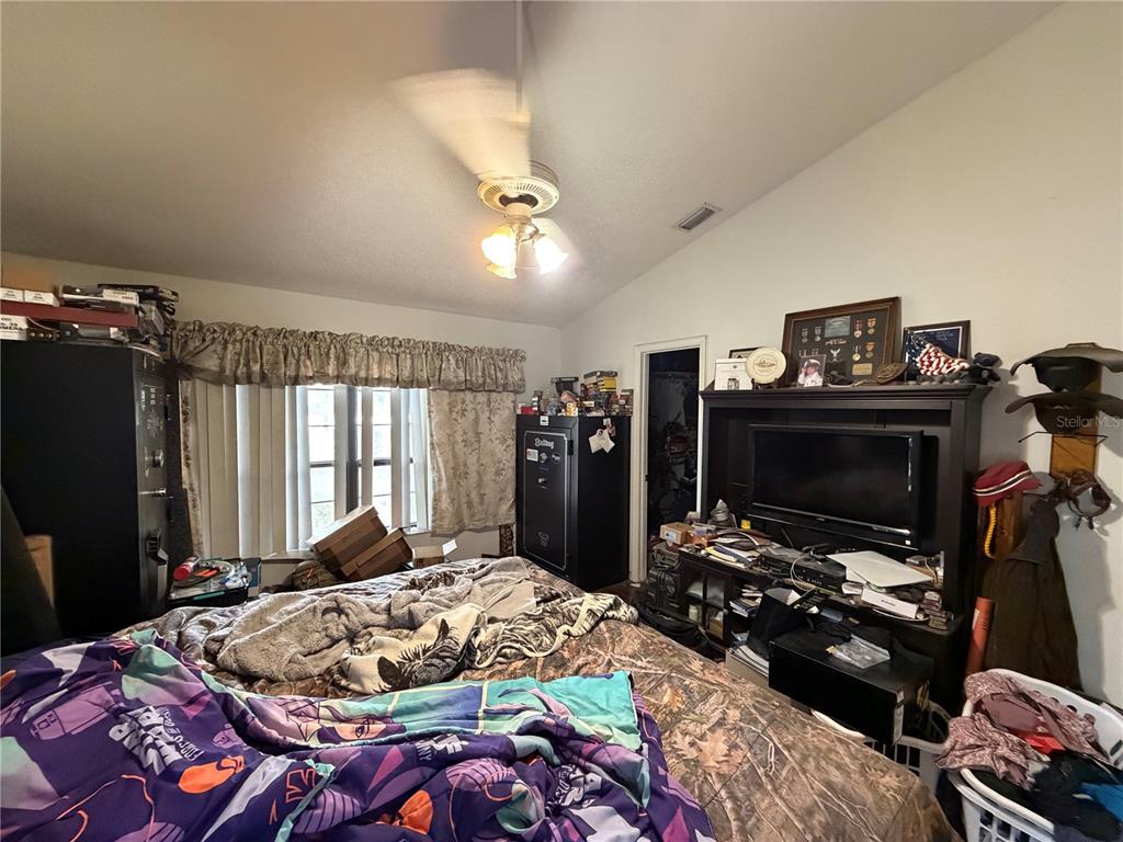 9 Hialeah Drive Ocala, FL 34482 - Photo 21 of 41 a bedroom with a bed a flat screen tv and a chandelier
