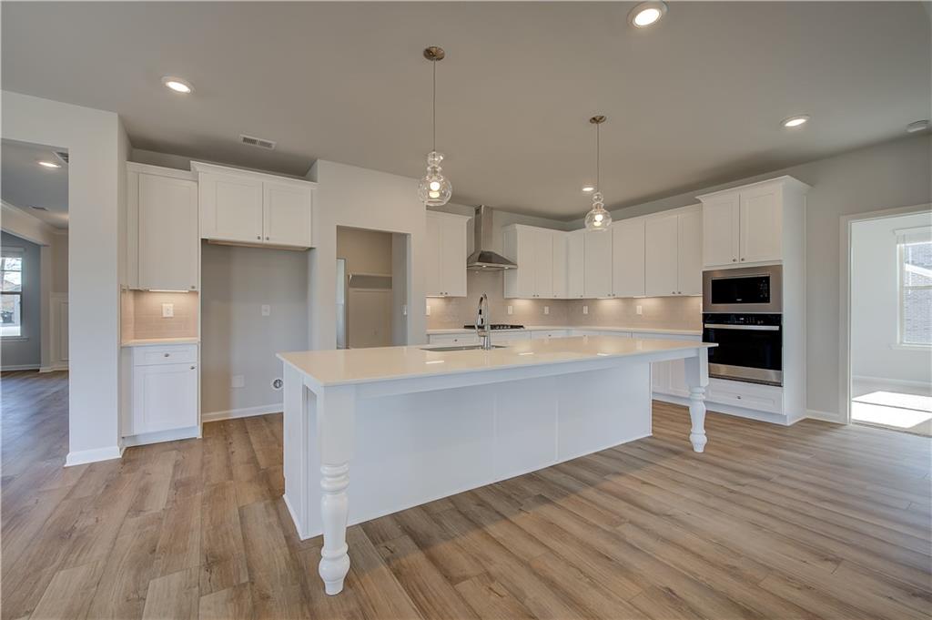 154 Haverling Pass Hampton, GA 30228 - Photo 12 of 36 a large kitchen with kitchen island a sink stainless steel appliances and cabinets