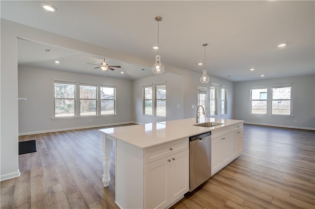 154 Haverling Pass Hampton, GA 30228 - Photo 15 of 36 a large kitchen with granite countertop a large counter top covered with wooden floors