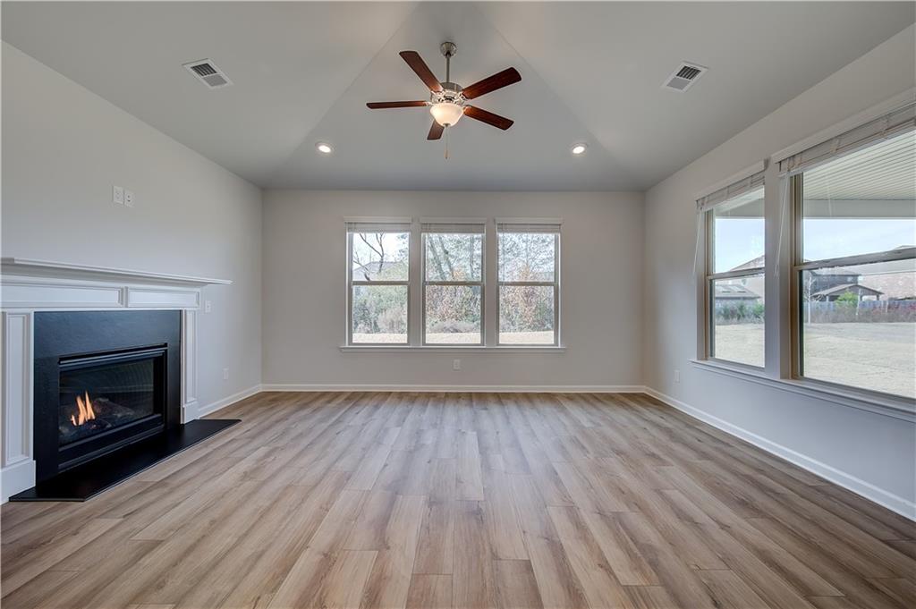 154 Haverling Pass Hampton, GA 30228 - Photo 18 of 36 a view of an empty room with wooden floor fireplace and a window
