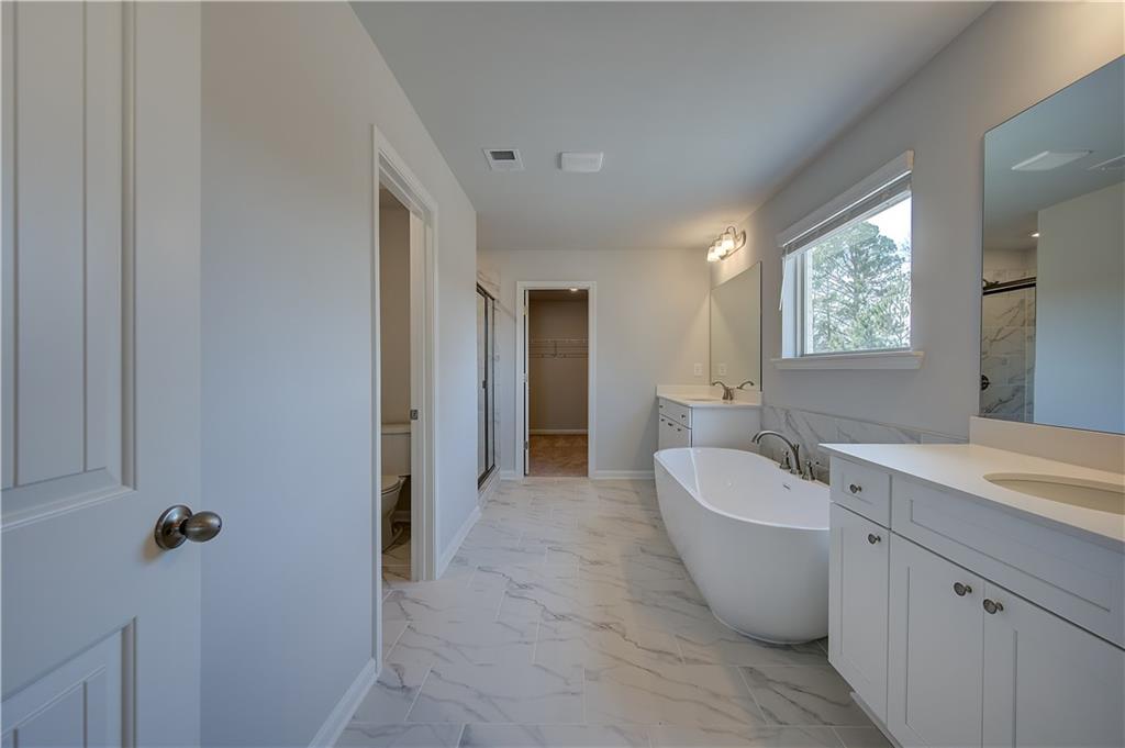 154 Haverling Pass Hampton, GA 30228 - Photo 28 of 36 a spacious bathroom with a double vanity sink mirror and bathtub