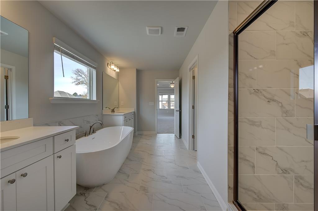 154 Haverling Pass Hampton, GA 30228 - Photo 31 of 36 a spacious bathroom with a bathtub sink and mirror