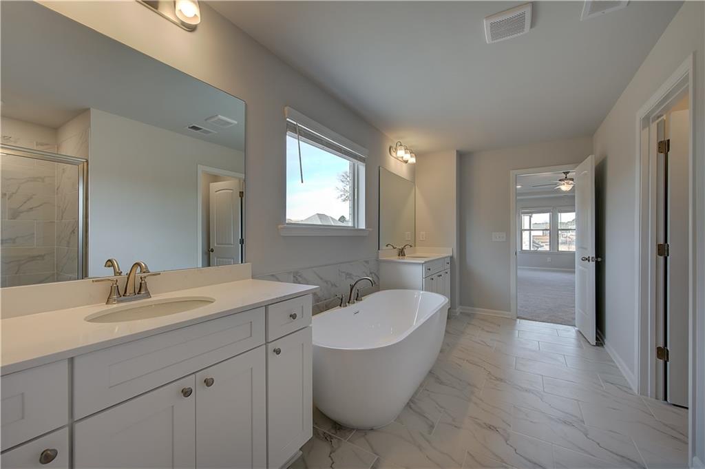 154 Haverling Pass Hampton, GA 30228 - Photo 32 of 36 a bathroom with a double vanity sink a mirror and a toilet