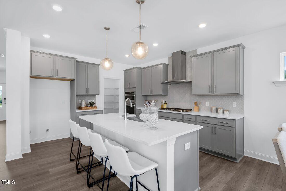 249 Tidal Pool Way Cary, NC 27519 - Photo 2 of 23 a kitchen with stainless steel appliances a stove a sink a refrigerator a center island a stove and white cabinets with wooden floor