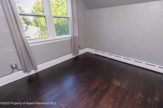 a view of a room with wooden floor and window