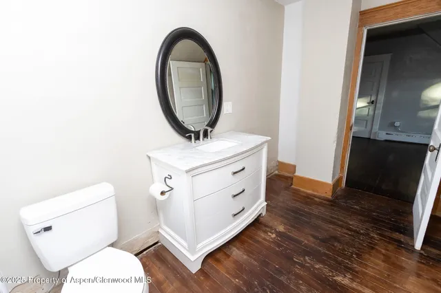 a bathroom with a toilet a sink and a mirror