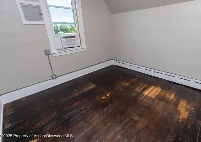 a view of a room with wooden floor and window