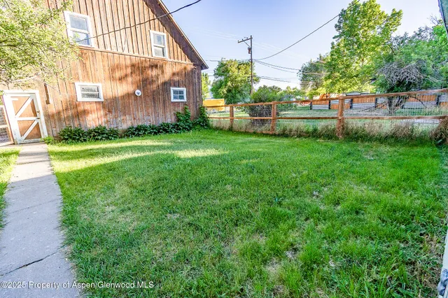 a view of a house with a big yard and a large tree