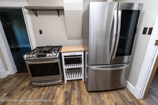 a kitchen with stainless steel appliances wooden floor sink and wooden cabinets