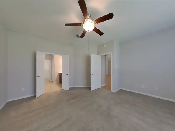 a view of empty room with ceiling fan