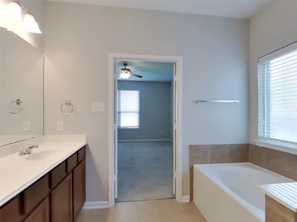 a bathroom with a tub sink and mirror