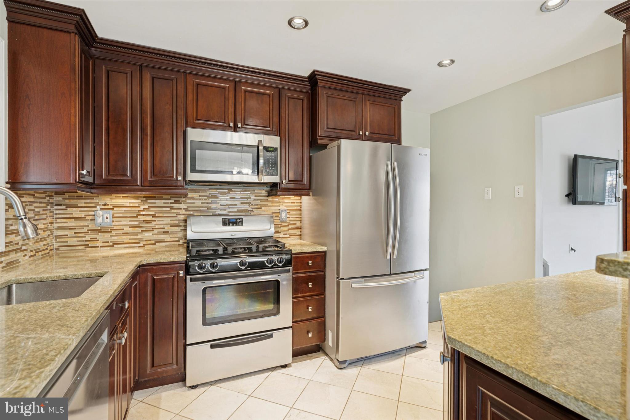 415 Milford Road Broomall, PA 19008 - Photo 8 of 29 a kitchen with granite countertop a refrigerator stove and microwave