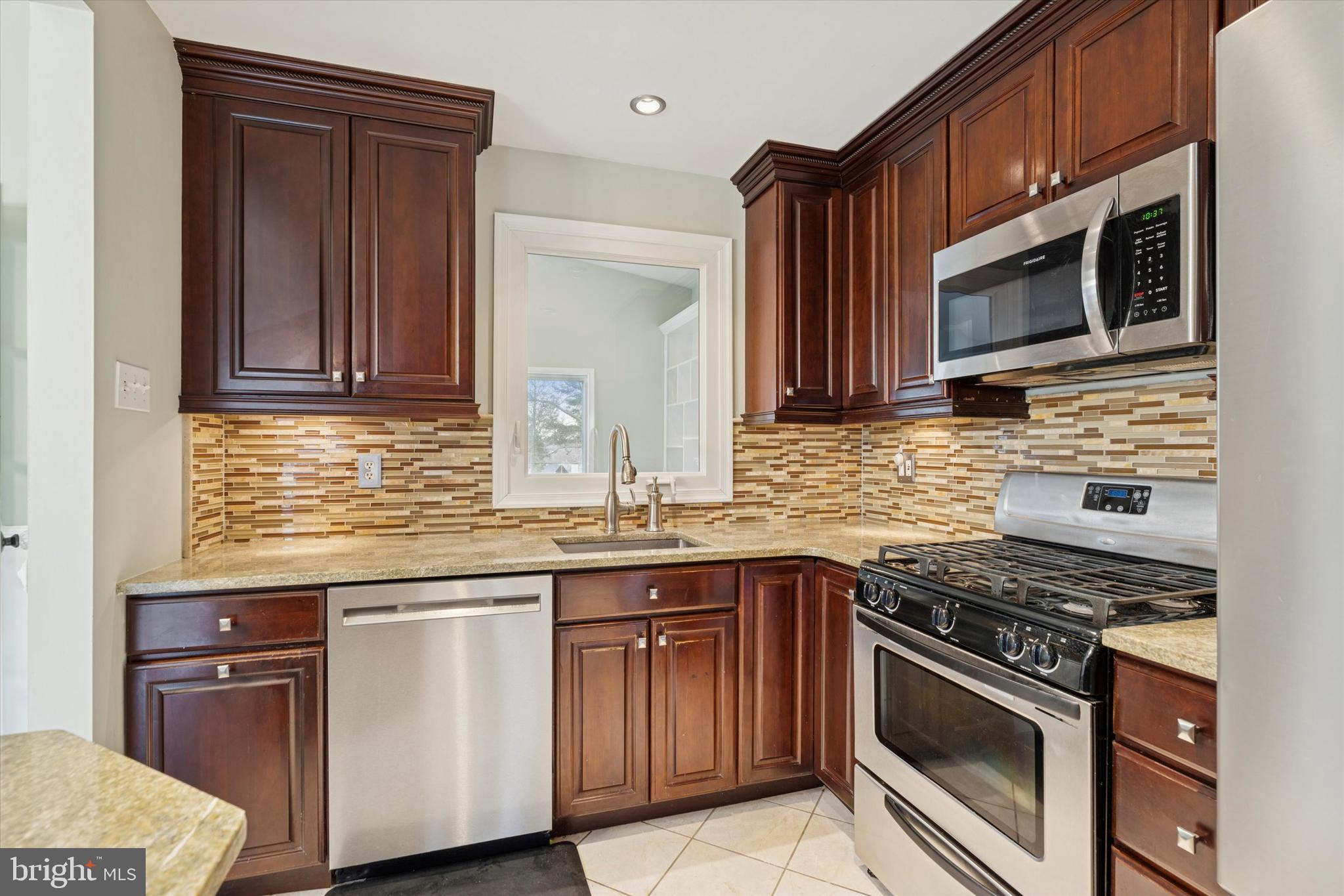 415 Milford Road Broomall, PA 19008 - Photo 10 of 29 a kitchen with granite countertop a sink stove and microwave