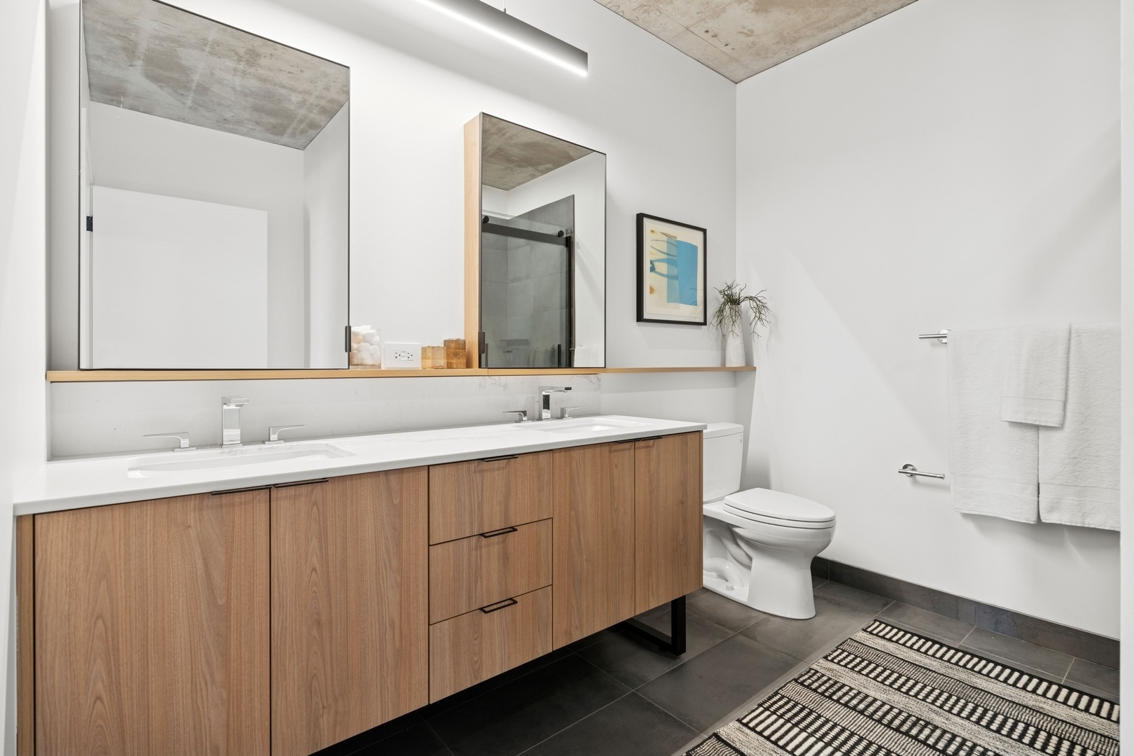 234 West Polk Street, Unit 3510 Chicago, IL 60607 - Photo 14 of 39 a bathroom with a double vanity sink a mirror and a toilet