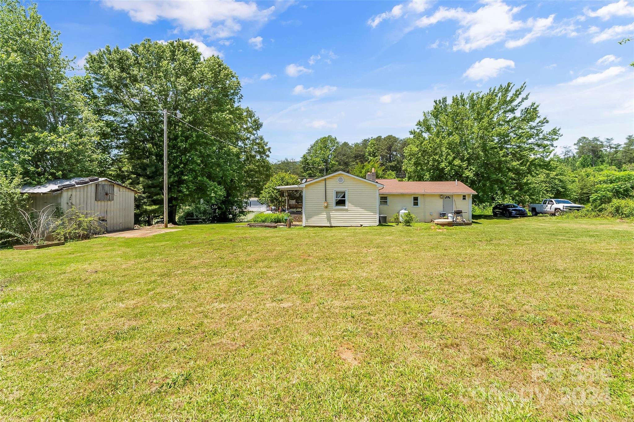 1529 Tatertown Loop Nebo, NC 28761 - Photo 22 of 38 a white house with a big yard and large trees