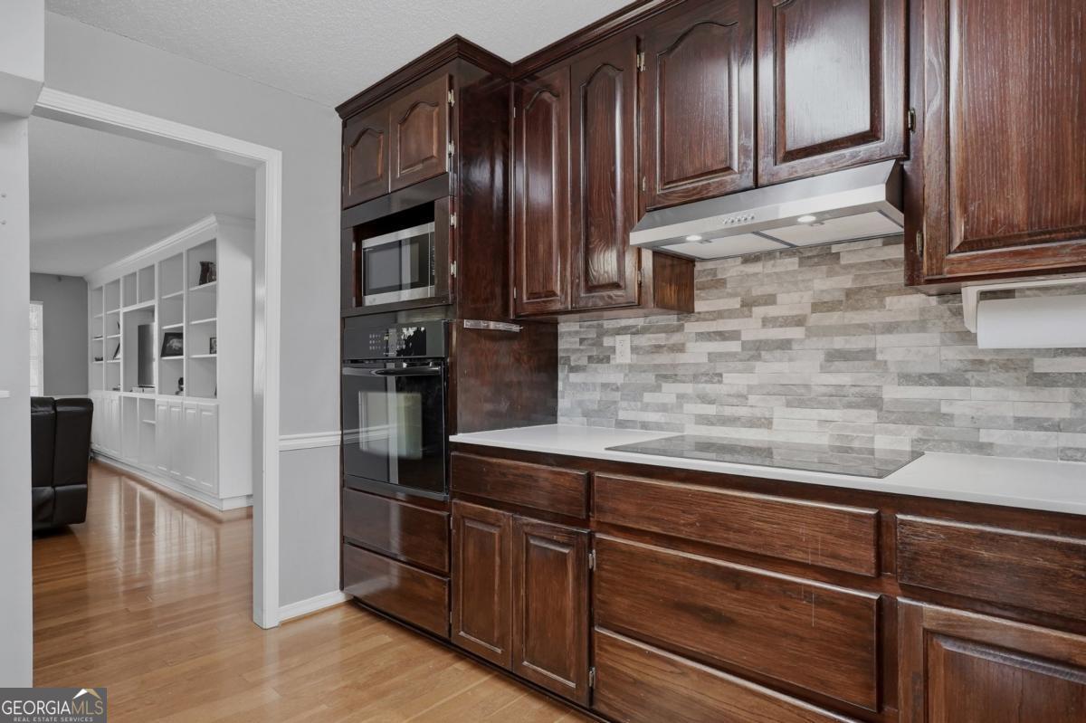 2811 Lullwater Road Tifton, GA 31794 - Photo 12 of 64 a kitchen with granite countertop stainless steel appliances wooden cabinets and a refrigerator