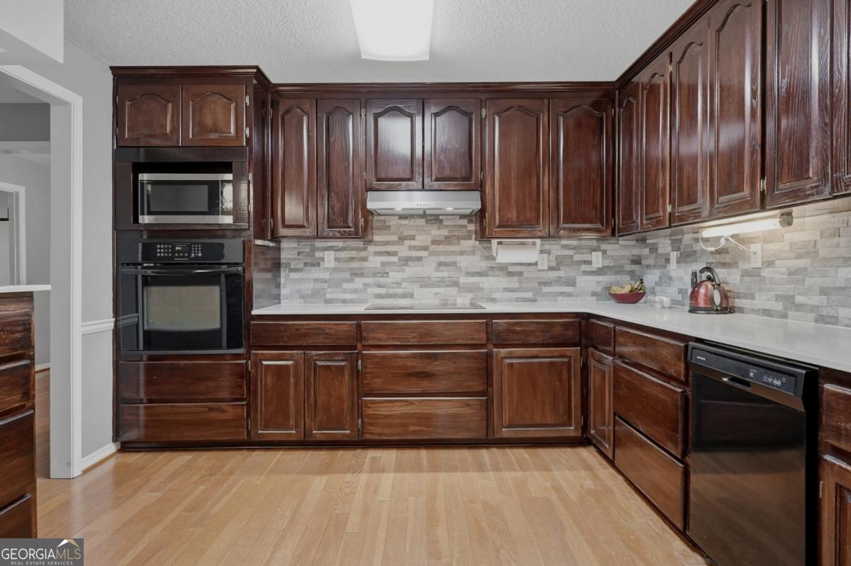 2811 Lullwater Road Tifton, GA 31794 - Photo 13 of 64 a kitchen with stainless steel appliances granite countertop wooden cabinets a stove top oven a sink and dishwasher