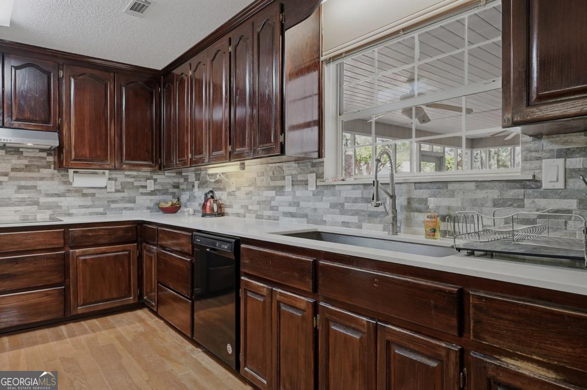 2811 Lullwater Road Tifton, GA 31794 - Photo 14 of 64 a kitchen with stainless steel appliances granite countertop wooden cabinets a sink and dishwasher