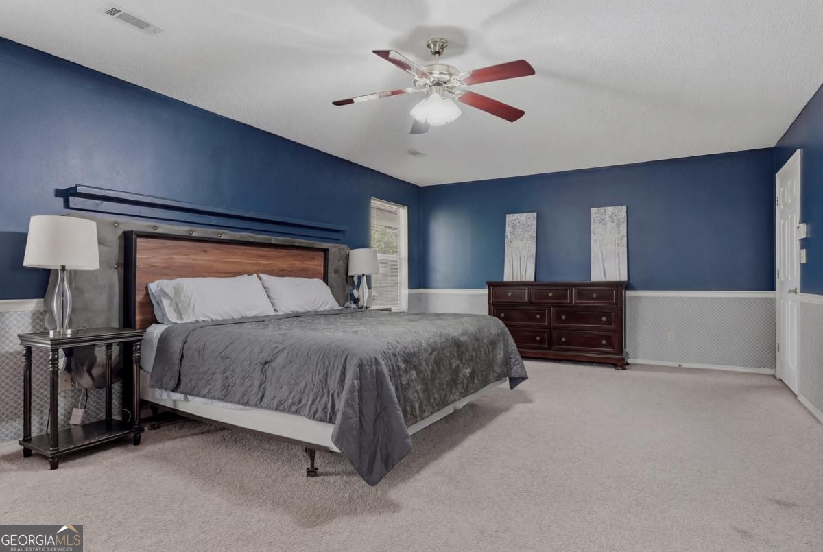2811 Lullwater Road Tifton, GA 31794 - Photo 22 of 64 a spacious bedroom with a bed and a chandelier