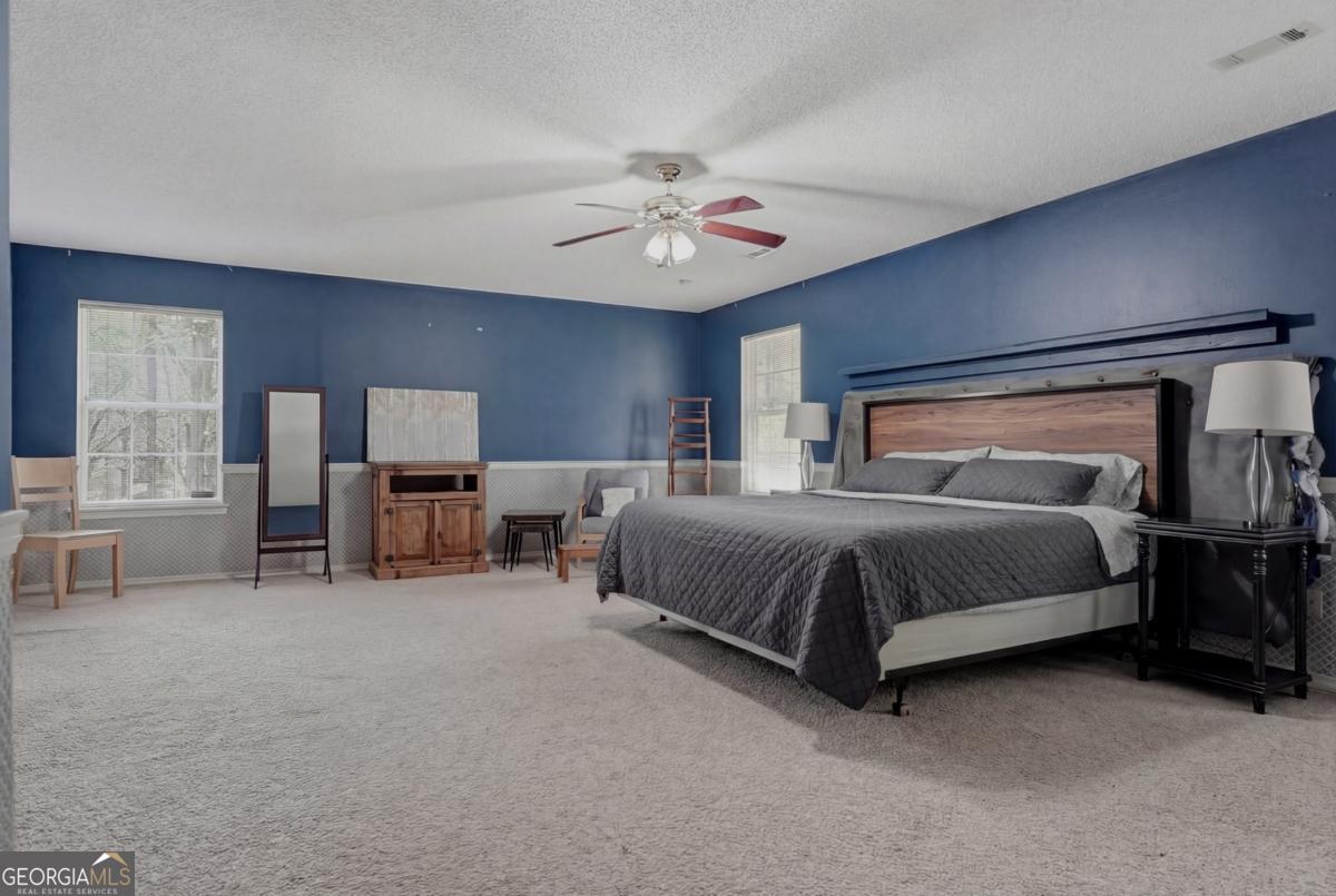 2811 Lullwater Road Tifton, GA 31794 - Photo 25 of 64 a spacious bedroom with a bed and a chandelier