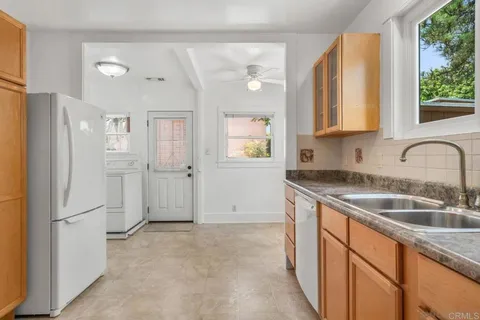 a kitchen that has a sink a refrigerator and window