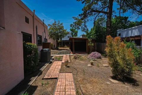 a view of a patio with table and chairs potted plants and large tree