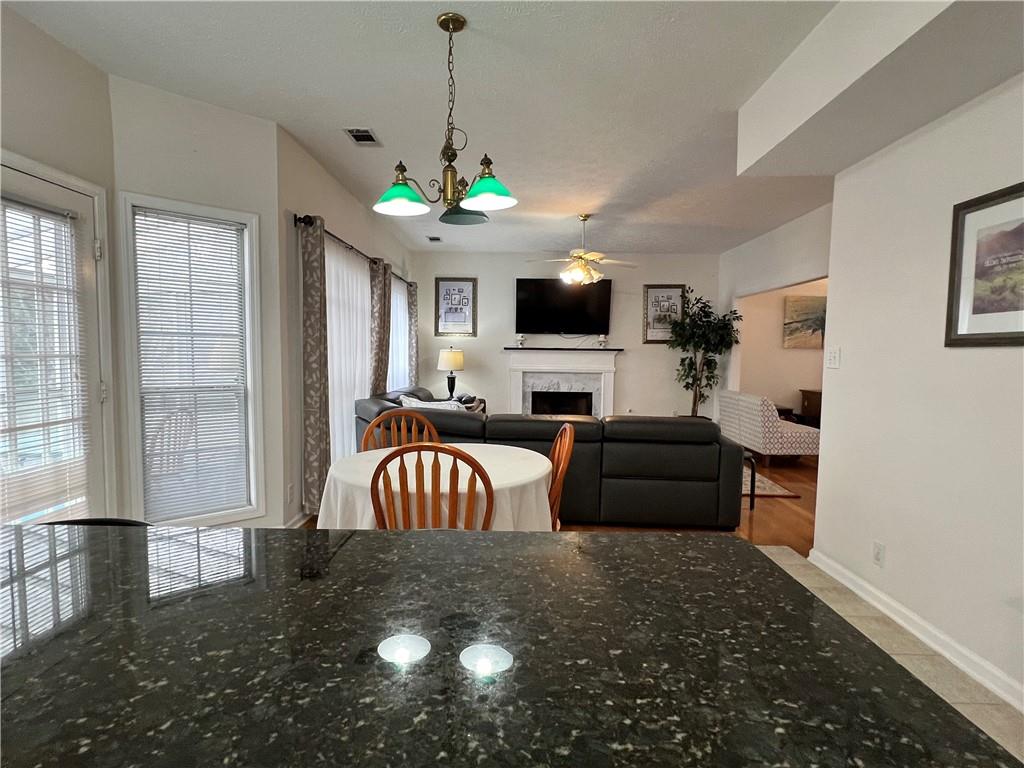 5415 Taylor Road Alpharetta, GA 30022 - Photo 11 of 29 a living room with furniture a fireplace and a flat screen tv