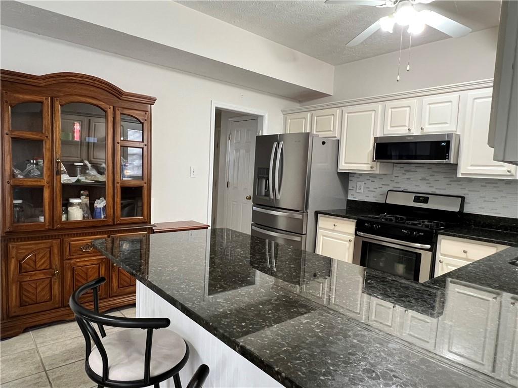 5415 Taylor Road Alpharetta, GA 30022 - Photo 16 of 29 a kitchen with stainless steel appliances granite countertop a stove refrigerator and microwave