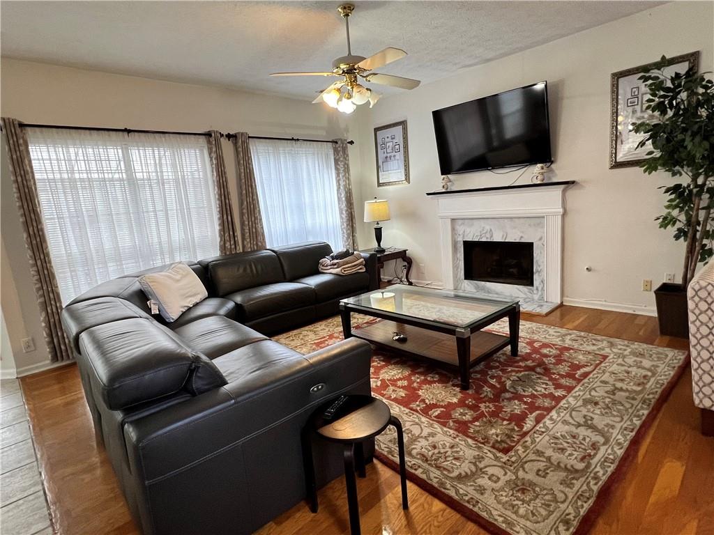 5415 Taylor Road Alpharetta, GA 30022 - Photo 9 of 29 a living room with furniture a flat screen tv and a fireplace