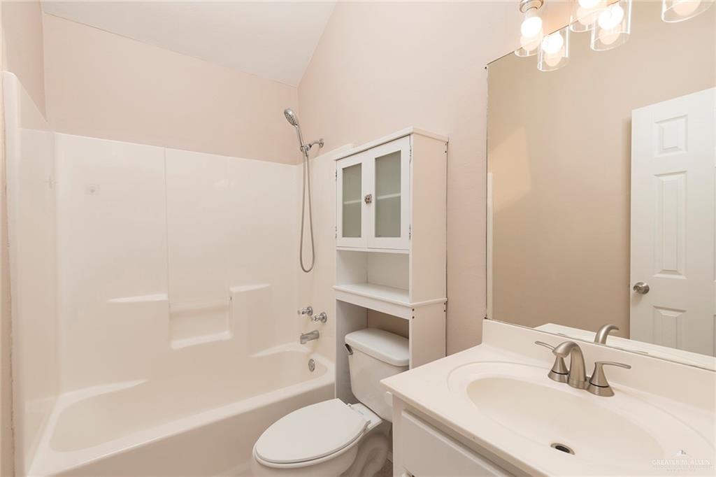 508 Patricia Street Mission, TX 78572 - Photo 7 of 24 Bathroom featuring a white vanity with an integrated sink, brushed nickel faucet, large wall mirror, and a multi-bulb light fixture