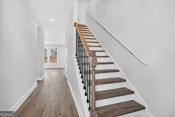a view of a hallway with wooden floor and entryway
