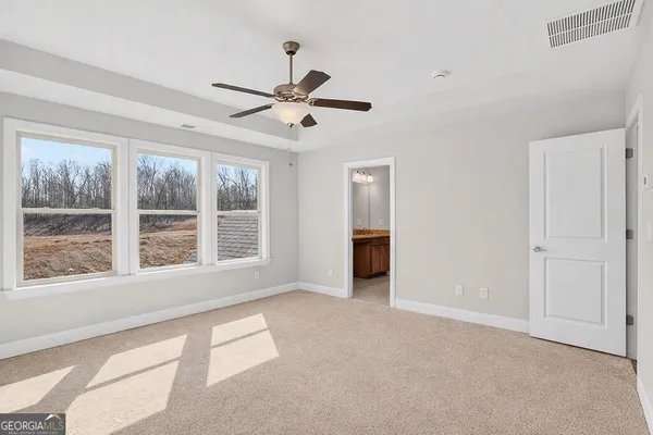 a view of a big room with a ceiling fan and a window