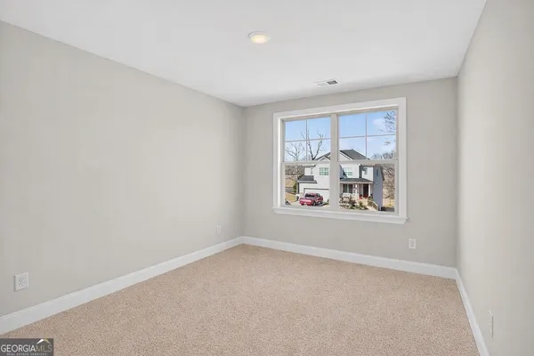 a view of an empty room with floor to ceiling window and stairs
