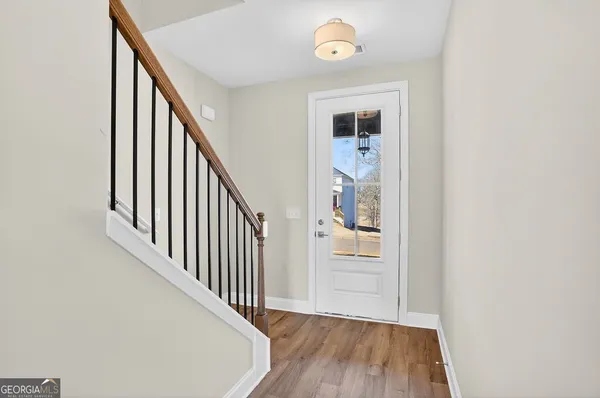 a view of a hallway with wooden floor and staircase