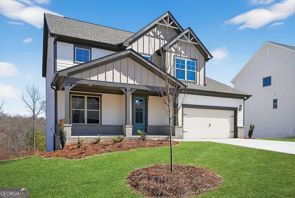 a front view of a house with a garden and yard