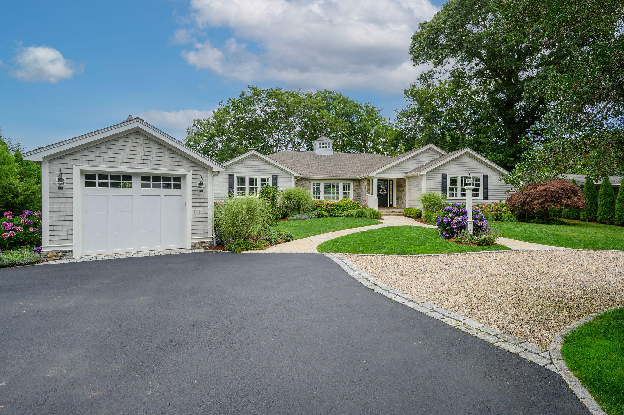 256 Holly Point Road Centerville, MA 02632 - Photo 10 of 53 a front view of a house with a yard and garage