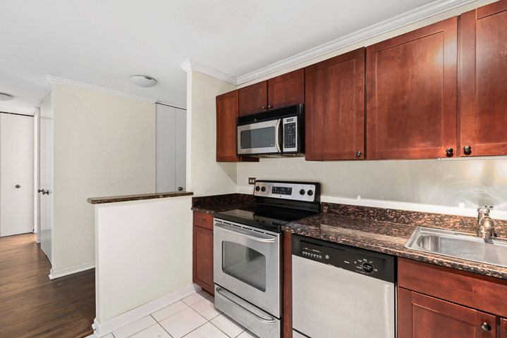 655 West Irving Park Road, Unit 4511 Chicago, IL 60613 - Photo 8 of 10 a kitchen with granite countertop cabinets stainless steel appliances and wooden floor