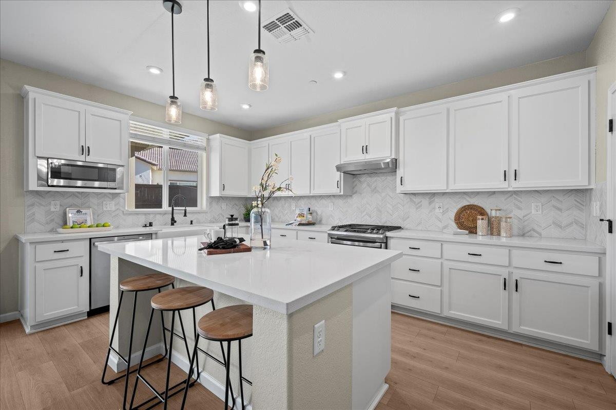 4828 Aldridge Ravine Court Folsom, CA 95630 - Photo 11 of 43 a kitchen with a sink stainless steel appliances and white cabinets