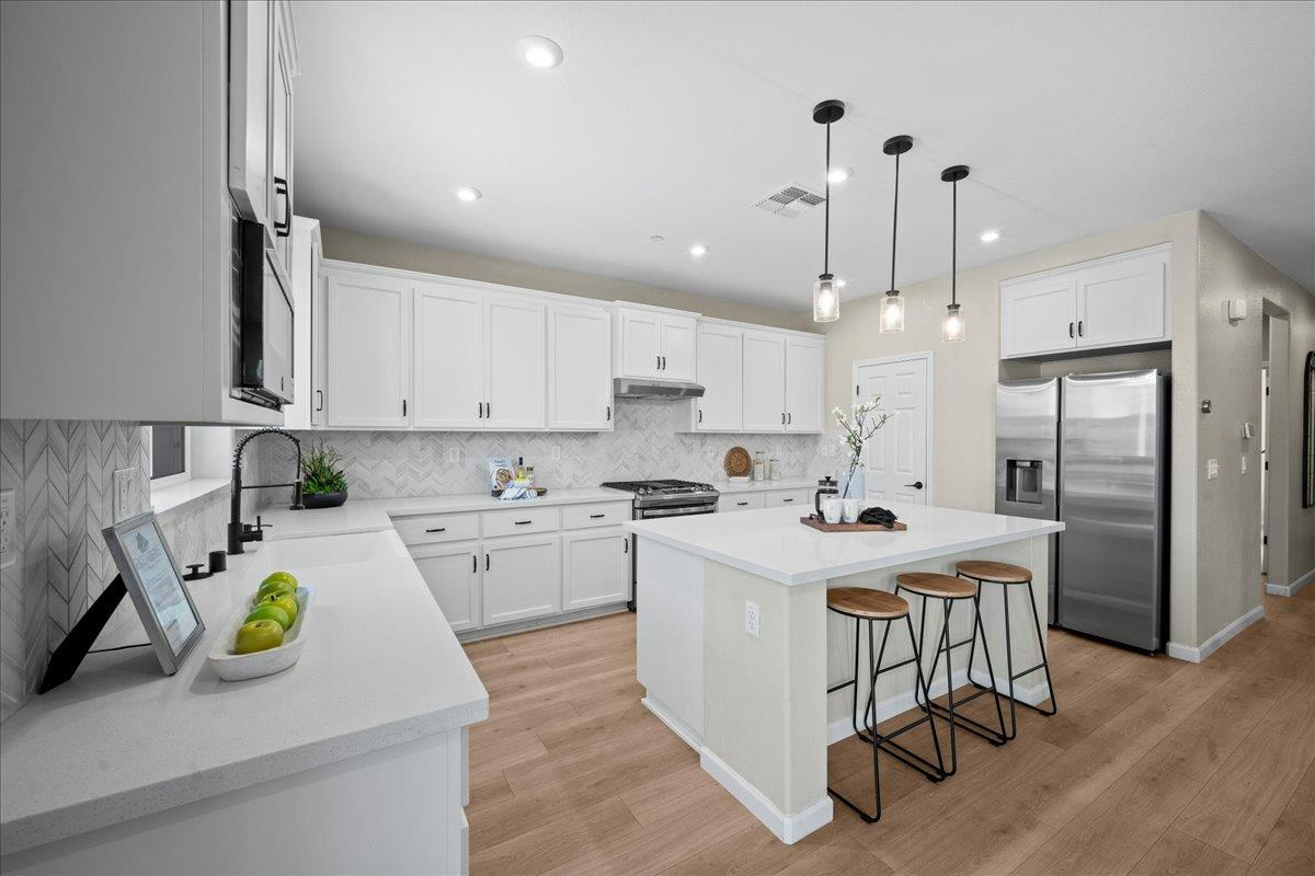 4828 Aldridge Ravine Court Folsom, CA 95630 - Photo 12 of 43 a kitchen that has a lot of white cabinets and stainless steel appliances