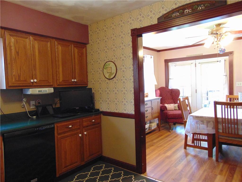 361 Adelaide Road Connellsville, PA 15425 - Photo 6 of 35 a kitchen with stainless steel appliances granite countertop a refrigerator a sink dishwasher a dining table and chairs with wooden floor