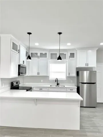 a kitchen with stainless steel appliances granite countertop a stove a sink and a refrigerator