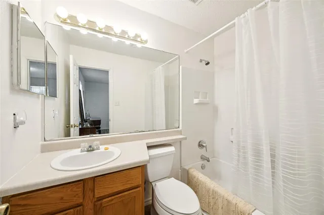 a bathroom with a sink vanity mirror and toilet